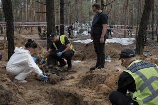 Ukrainian police are collecting evidence that will be used to identify and determine possible war crimes from bodies found at a gravesite at the entrance to Izum. Kharkiv region, Ukraine, September 17, 2022. (Photo by Antoni Lallican / Hans Lucas / Hans Lucas via AFP)