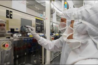 Des ouvriers de l’usine de microprocesseurs de STMicroelectronics à Crolles (Isère) vérifient une machine de fabrication de carbure de silicium.
