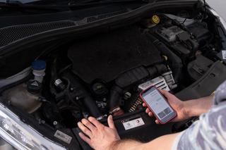 Le propriétaire d’une Peugeot 208, consultant la page de la plateforme d’action collective MyLeo, se tient devant le moteur 1.2 PureTech de son véhicule, à Volvic (Puy-de-Dôme) le 7 juin 2024.