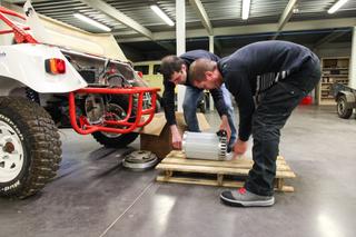 Des ingénieurs preparent le montage d’un moteur electrique sur un vehicule tout terrain.