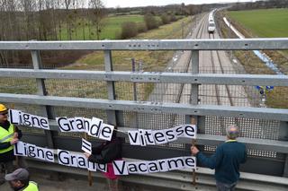 Des manifestants tiennent une banderolle de protestation sur un pont au-dessus des voies de la nouvelle ligne à grande vitesse Le Mans-Rennes, le 17 mars 2018.