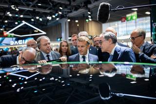 Le président de la République Emmanuel Macron (au centre) visite le stand Renault au Mondial de l’automobile de Paris, avec Luc Chatel, président de la PFA (à gauche), et le directeur général de Renault François Provost (à droite), le 12 octobre 2026.